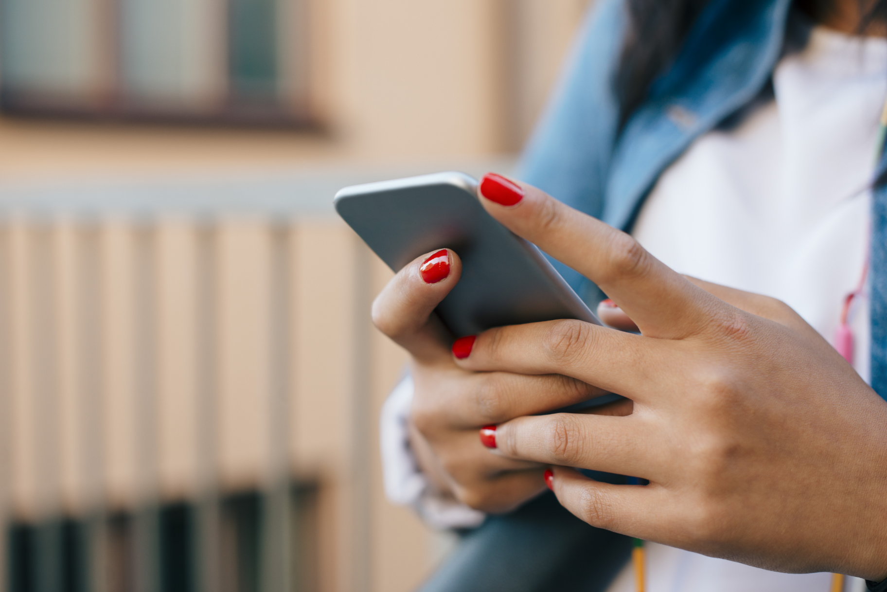 Frauenhände mit Smartphone draussen
